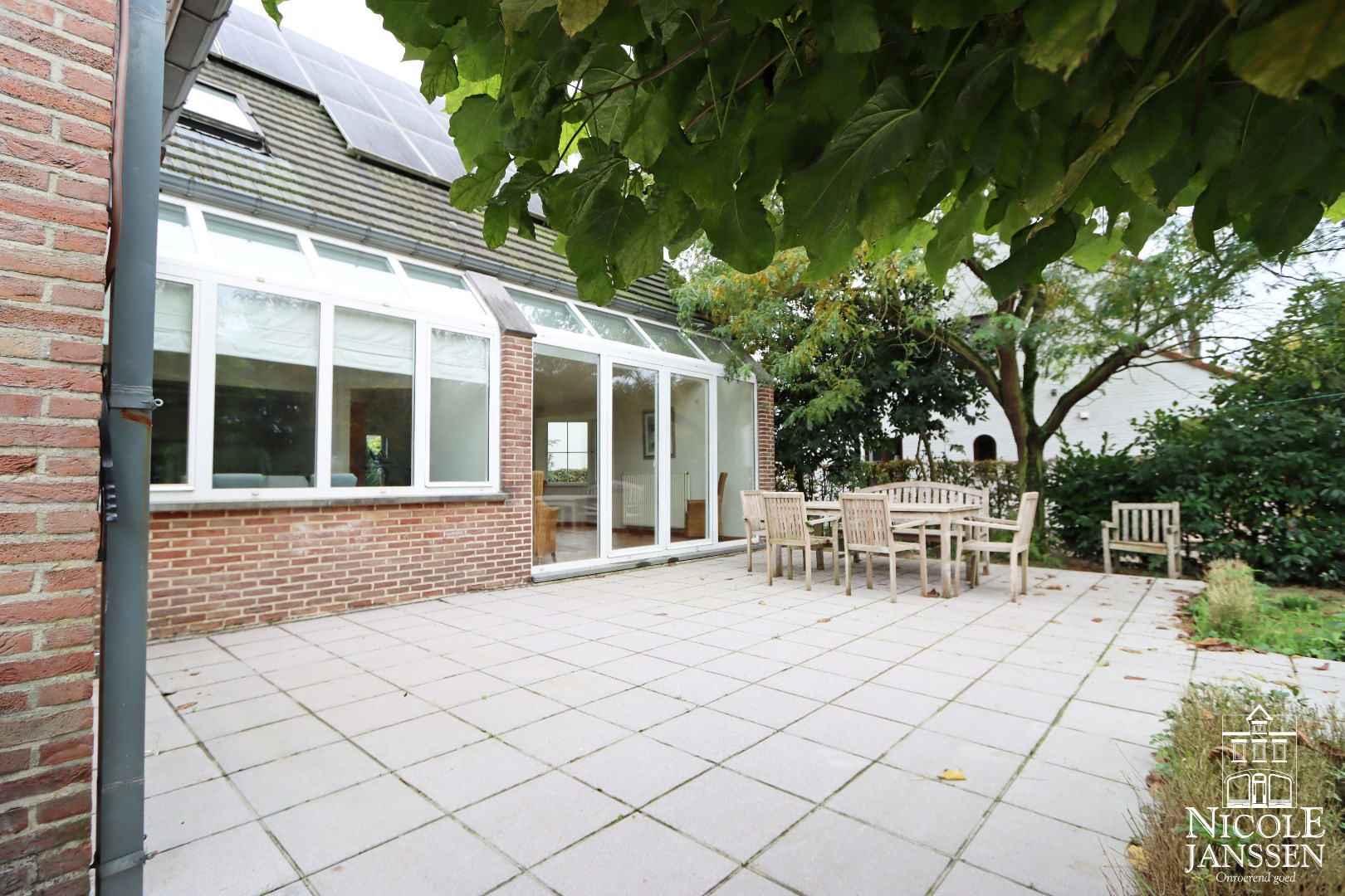 Betegeld ruim terras aan de achterzijde van het huis