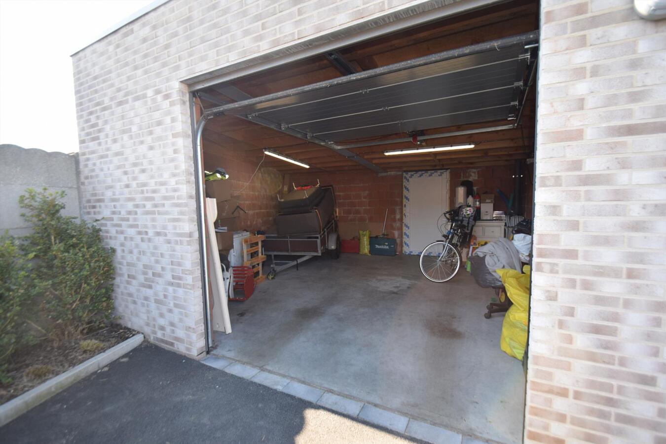 Ruime en recente gesloten garage met sectionale poort en uitweg achteraan 