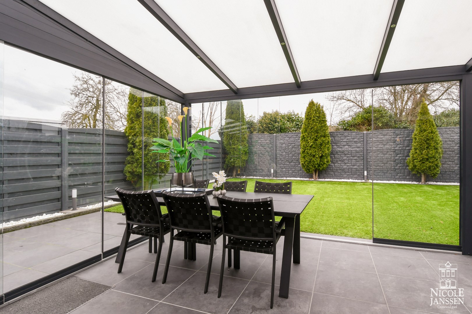 Overdekt terras met uitzicht op de tuin en openschuifbare glazen panelen