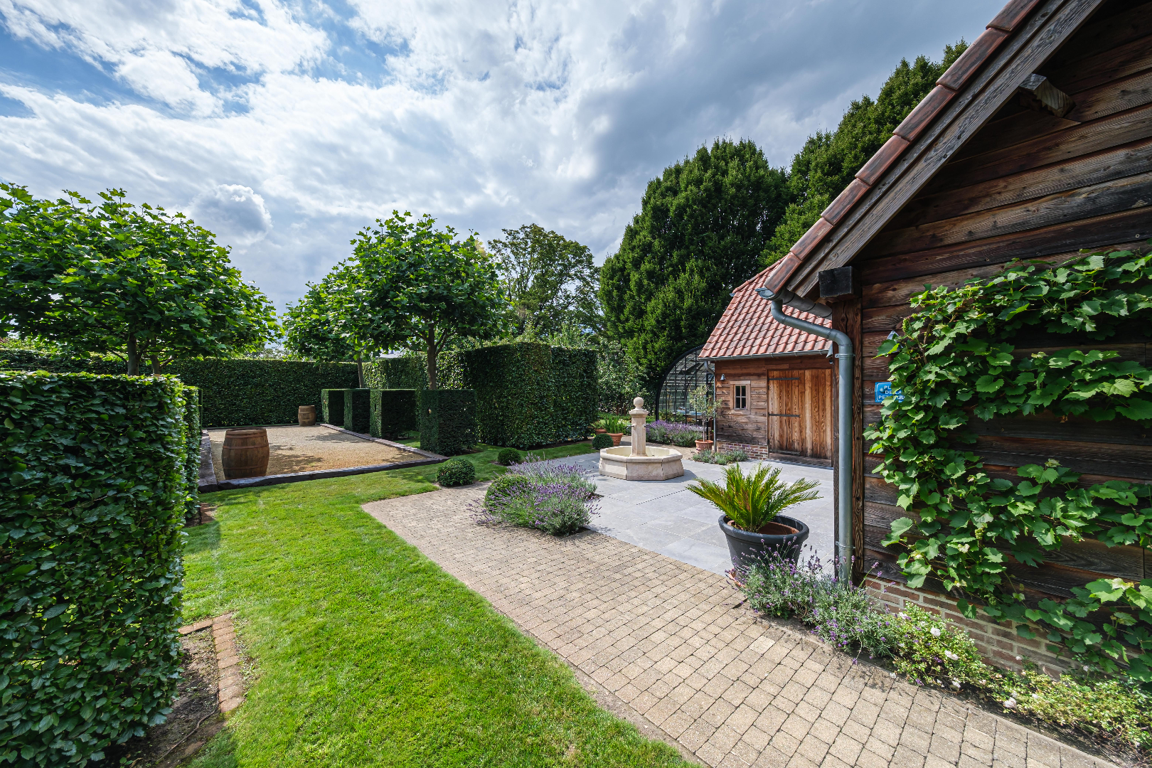 Luxueus ingericht landhuis met prachtige tuin met zwembad, poolhouse en ingericht houten bijgebouw 