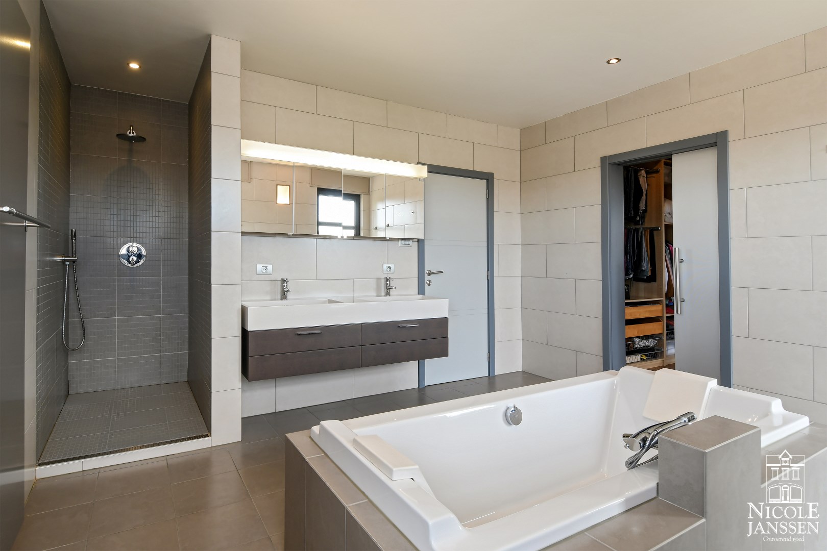 Ruime badkamer met grote inloopdouche en dubbele wastafel 