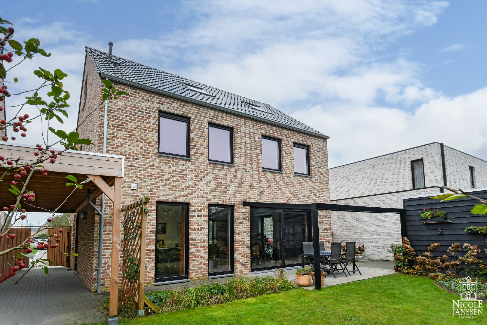 Afgesloten carport aan de zijkant van de woning en praktische tuinberging voor motor, fietsen of tuinmateriaal 