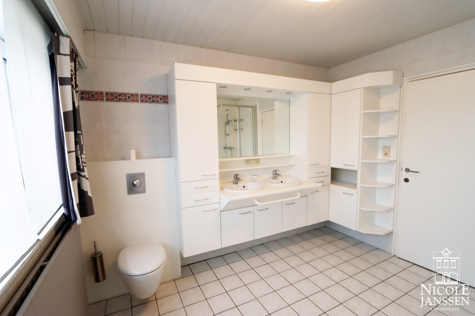 Badkamer met douche, ligbad, toilet en twee wastafels