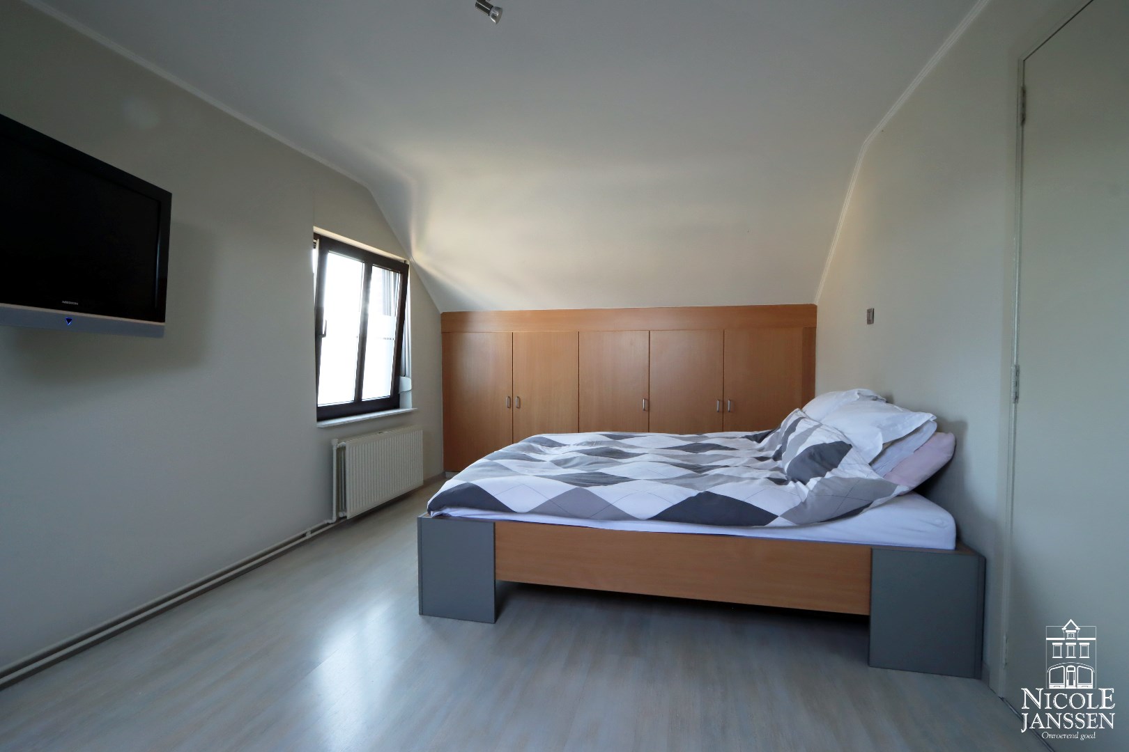 Slaapkamer met laminaatvloer en inbouwkasten