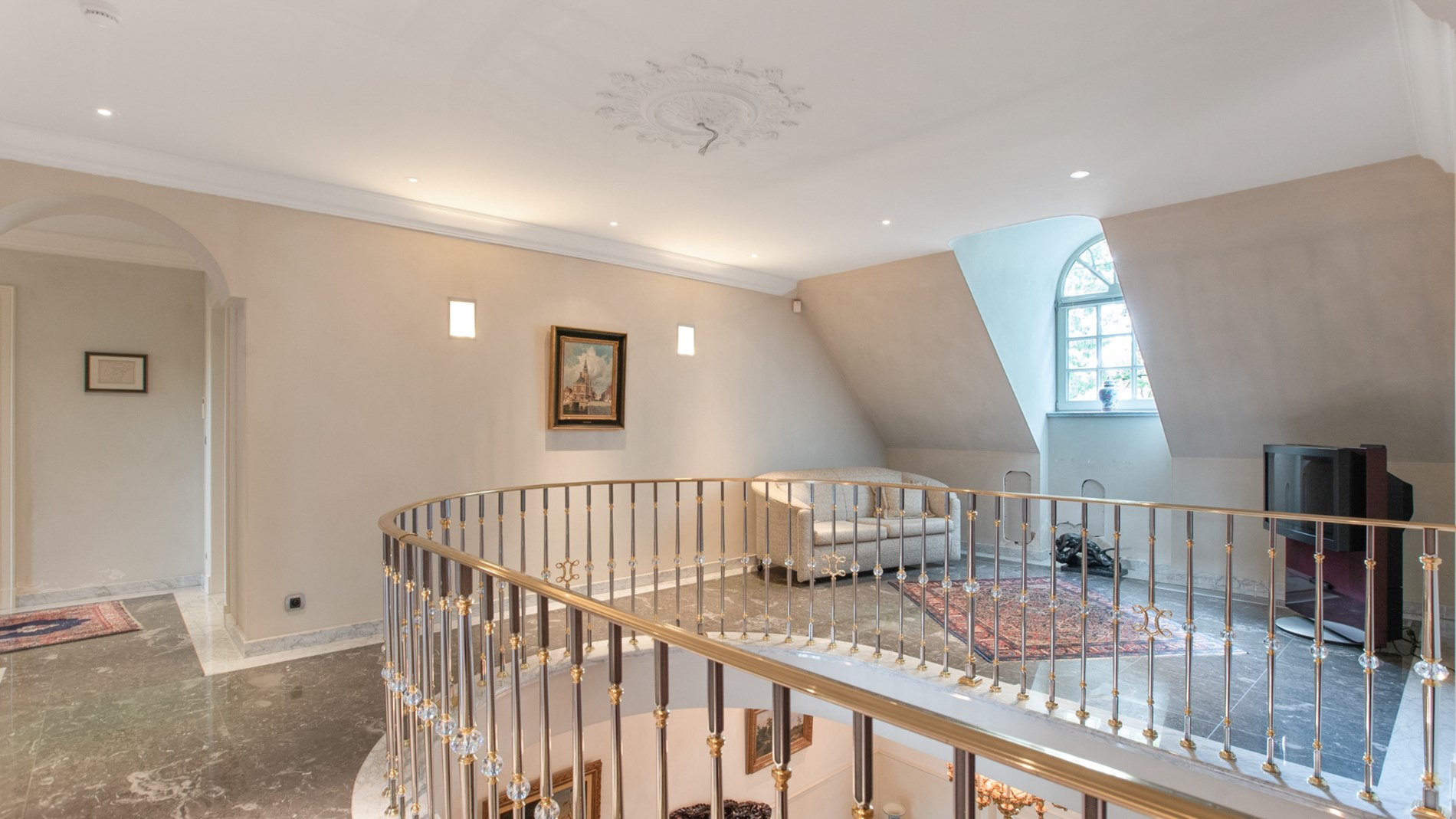 Trappenhal met sierlijke goudkleurige leuning 
