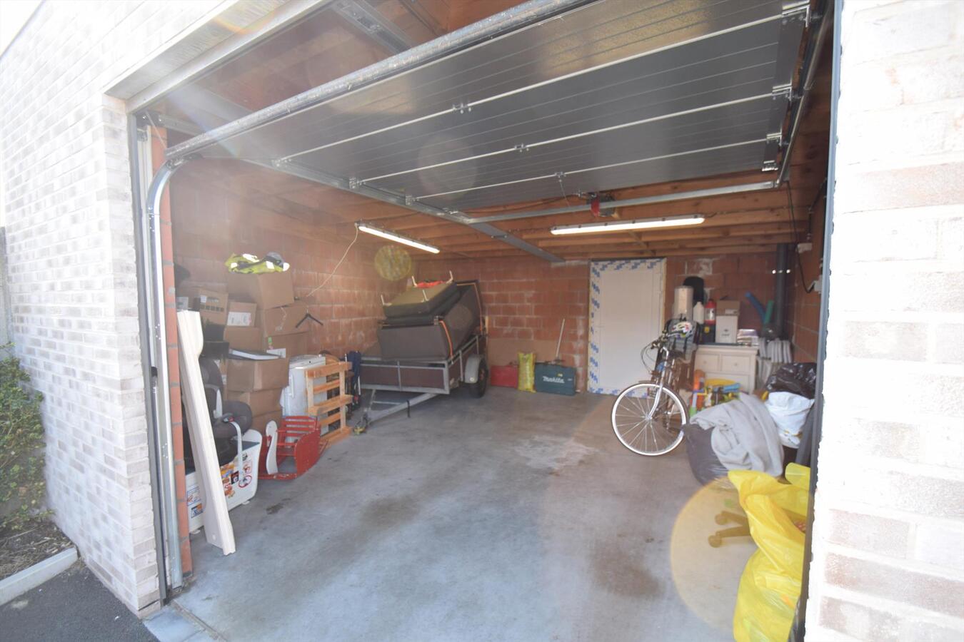Ruime en recente gesloten garage met sectionale poort en uitweg achteraan 